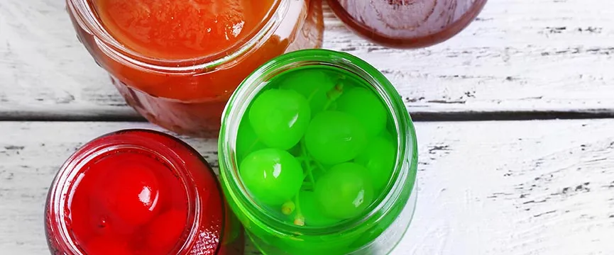 Candied fruits in different colours and some other types of preserved fruit.